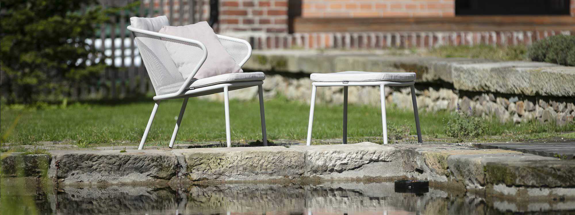 White Condor garden relax chair & foot stool next to water
