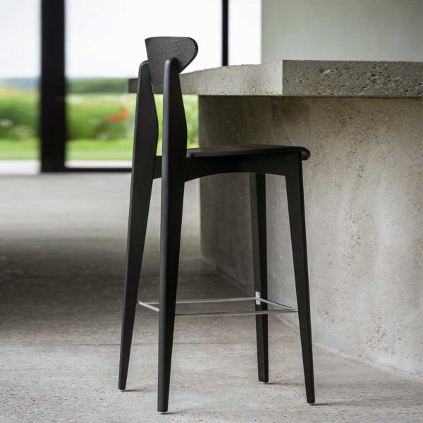 Ink bar chair in Black stained oak designed by Sergio Herman pictured next to poured concrete bar counter