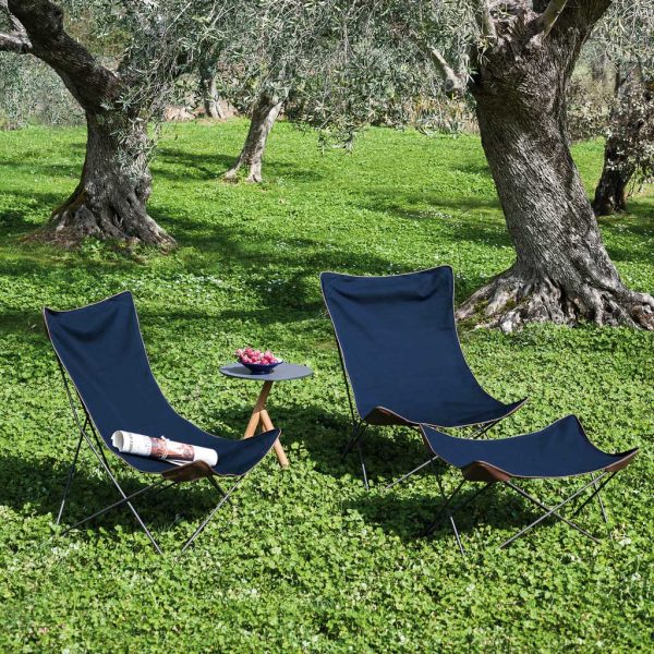 Pair of blue-coloured Lawrence folding lounge chairs with footstool on grassy lawn in olive orchard