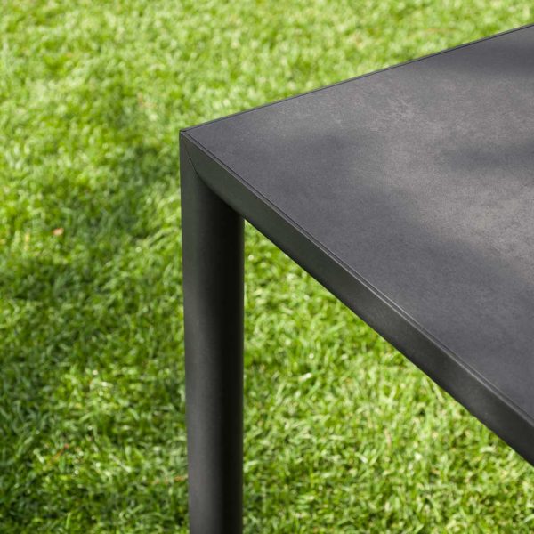 Detail of Plein Air modernist table's leg and frame, shown against grassy lawn