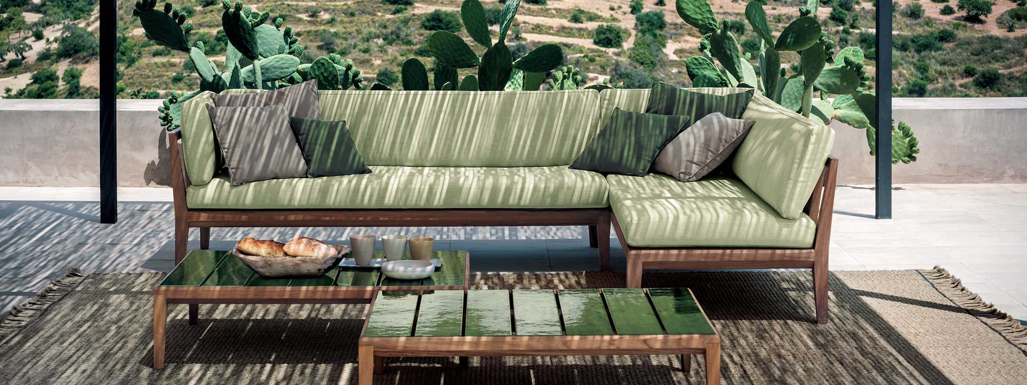 Teka outdoor corner sofa and Teka low table beneather pergola with cacti in background